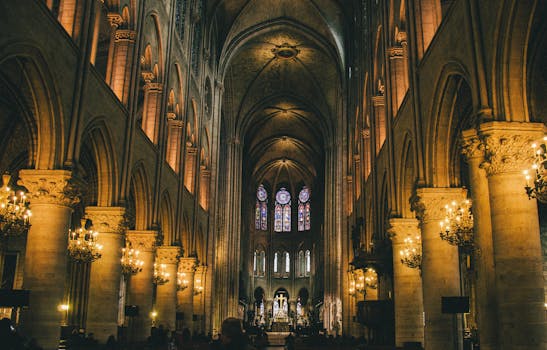 Elegant interior of Notre Dame Cathedral in Paris with Gothic architecture and chandeliers.