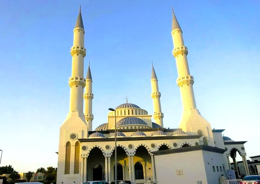 Al Farooq Omar Bin Al Khattab Mosque: A Visitor's Guide to Dubai's Blue Mosque 2 Al Farooq Omar Bin Al Khattab Mosque in Dubai with its domes and four white minarets against a blue sky