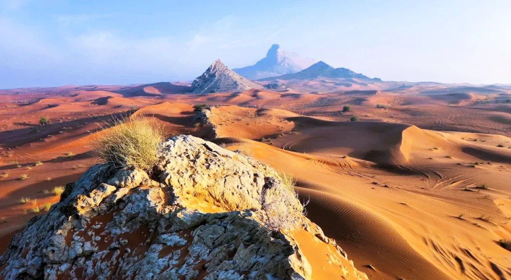 Fossil Rock Sharjah: How to Visit, Hiking Trail, Places Nearby and Where to Stay 3 Desert dunes and rocky peaks seen from the Fossil Rock hiking trail in Mleiha, Sharjah