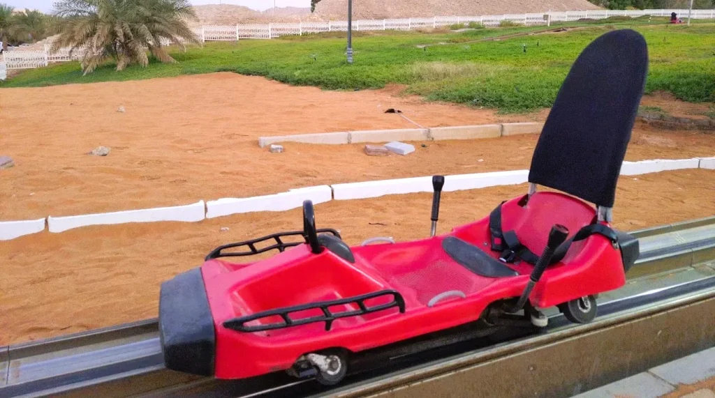 Mini Train Hot Spring in Al Ain, Abu Dhabi: Tickets, Timings and Tips 3 Red mini train hot spring cart with seat belt and hand levers on its rail in Al Ain